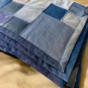 • Material: Made with high-quality, upcycled denim and soft cotton fabric for durability and comfort.
 • Design: A beautiful patchwork pattern featuring various shades of blue, accented by pops of color for a modern, rustic aesthetic.