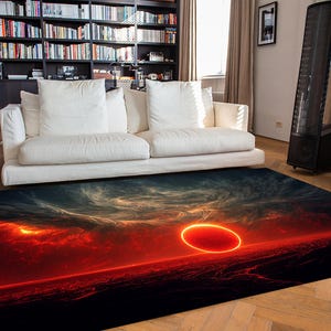 May include: A rectangular area rug with a dramatic sunset design. The rug features a fiery red and orange color palette with a large, glowing circular shape in the center, evoking a celestial or planetary theme. The rug is placed in a living room setting.