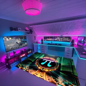Op de afbeelding: Een moderne gamekamer met neonverlichting in roze en blauwe tinten. De kamer heeft een groot bureau met meerdere monitoren, een gaming-pc en een aangepaste vloermat met een Pi-symbool. Een grote tv toont het spel "Ghost".