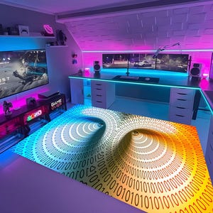 May include: A modern gaming setup with a large screen showing a video game, a desk with multiple monitors, and a computer. A rug with a binary code tunnel design is in the centre of the room. The room is lit with neon lights in shades of pink and blue.