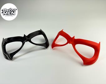 Peut inclure: Deux masques en plastique, l'un noir et l'autre rouge, conçus pour ressembler à des masques d'yeux de super-héros.
