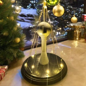 A 1:16 scale water tower adorned with festive Christmas lights.