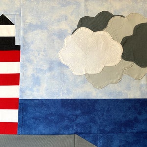 Könnte beinhalten: Ein rot-weiß gestreifter Leuchtturm mit schwarzem Dach vor blauem Himmel mit grauen Wolken.