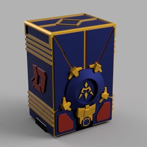 Op de afbeelding: Een blauwe en gouden decoratieve doos met een geometrisch ontwerp. De doos heeft een cirkelvormig embleem en rode accenten. De doos heeft een rechthoekige vorm met gouden randen en een gedetailleerd, gestileerd ontwerp.