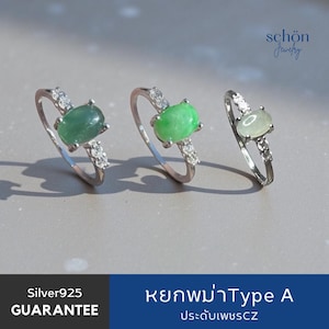 Peut inclure: Trois bagues en argent avec des pierres vertes de taille ovale et de petites pierres transparentes sur les anneaux. Le texte "schön Jewelry" est en haut à droite, et le texte en bas indique "Silver925 GUARANTEE" et "หยกพม่าType A ประดับเพชรCZ".