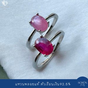 Peut inclure: Deux bagues en argent avec des pierres précieuses ovales. La bague supérieure porte une pierre cabochon rose clair lisse, tandis que la bague inférieure présente une pierre rouge foncé à facettes. Les deux ont des anneaux en argent poli.