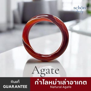 Peut inclure: Un bracelet jonc circulaire en pierre d'agate naturelle polie, présentant des teintes rouge profond et orange brûlé avec des bandes blanches translucides. Le texte "schön Jewelry", "Agate", "GUARANTEE" et "Natural Agate" est visible.