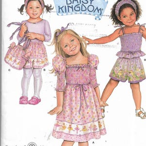 May include: Simplicity sewing pattern 2992 with girls' clothing designs. The image shows illustrations of dresses, shorts, and tops with floral and ballet-themed patterns. The pattern includes sizes A 1/2, 1, 2, 3, and 4.