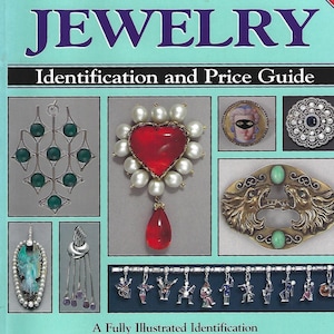 May include: A book titled Warman's Jewelry Identification and Price Guide by Christie Romero. The light blue cover features various jewellery pieces including a heart-shaped brooch with pearls, a cameo, and a charm bracelet with figures.