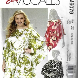 May include: McCall's sewing pattern M6079 featuring a woman wearing a green and white floral print tunic with a matching belt. The pattern includes other tunic designs in pink and black patterns. The text "Easy McCall's" is visible.