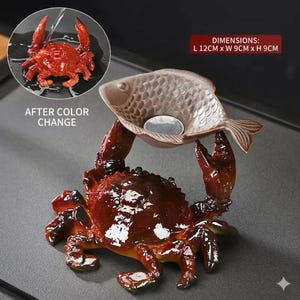 以下が含まれることがあります： カニの形をした装飾品で、魚の形をしたボウルを持っています。カニは光沢のある仕上げの濃い赤茶色です。魚のボウルは薄茶色です。寸法は約12cmの長さ、9cmの幅、9cmの高さです。