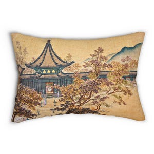 Könnte beinhalten: Rechteckiges Kissen mit einem Vintage-asiatischen Landschaftsgemälde. Das Kunstwerk zeigt einen Tempel mit einem mehrstufigen Dach, umgeben von Bäumen mit rosa und gelbem Laub und einer Bergkette. Das Kissen hat einen beigen Hintergrund.
