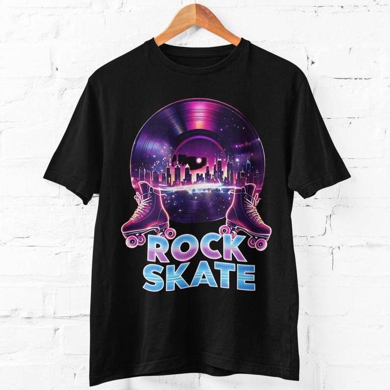 May include: Black t-shirt featuring a retro design with a vinyl record and roller skates. The record has a cityscape and starry sky. The words "ROCK SKATE" are in a gradient blue and pink font.