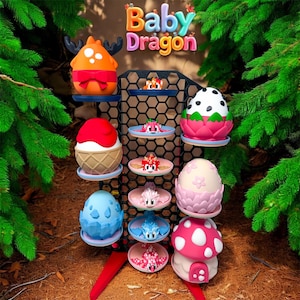 May include: A display of colourful, whimsical dragon-themed figurines and egg-shaped sculptures. The display includes an orange dragon with antlers, ice cream cone-shaped figures, and mushroom-shaped houses. The text "Baby Dragon" is at the top.