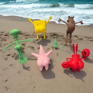 May include: A collection of colorful cartoon character figures, including a yellow sponge, a pink starfish, a green squid, a brown beaver, a red crab, and a small green creature, are arranged on a sandy beach with the ocean in the background.