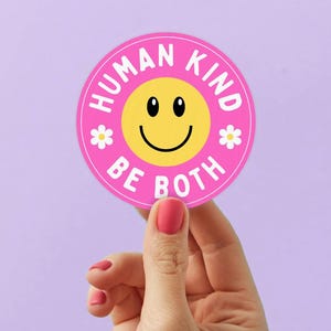 May include: A white ceramic mug with a black handle and the text "But First, Coffee" in a black, handwritten-style font. The mug is on a white surface.