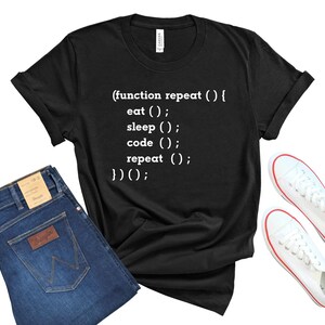 Peut inclure: T-shirt noir avec du texte blanc qui dit : "(function repeat () { eat (); sleep (); code (); repeat (); })();"