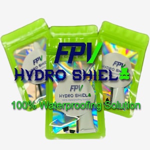 Puede incluir: Tres bolsas de plástico verde que contienen una solución impermeabilizante. Cada bolsa tiene un interior holográfico y una etiqueta blanca con el texto "FPV HYDRO SHIELD" y "100% Waterproofing Solution".