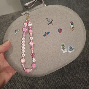 Handmade pink phone charm that is fully customisable. Each pink Y2K phone charm is made from upcycled pink beads, personalised with your name. Each custom phone charm is unique and makes a great gift for her, perfect for the Y2K trend. The pink phone straps are super cute and personalised, making a great Y2K phone accessory. The beaded pink phone wristlet is a great Y2K phone charm for any pink lover.