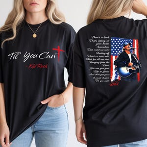 Può includere: T-shirt nera con la scritta "Til' You Can" e "Kid Rock" in bianco e rosso. La parte posteriore della maglietta presenta l'immagine di un cantante con una bandiera americana e il testo della canzone.