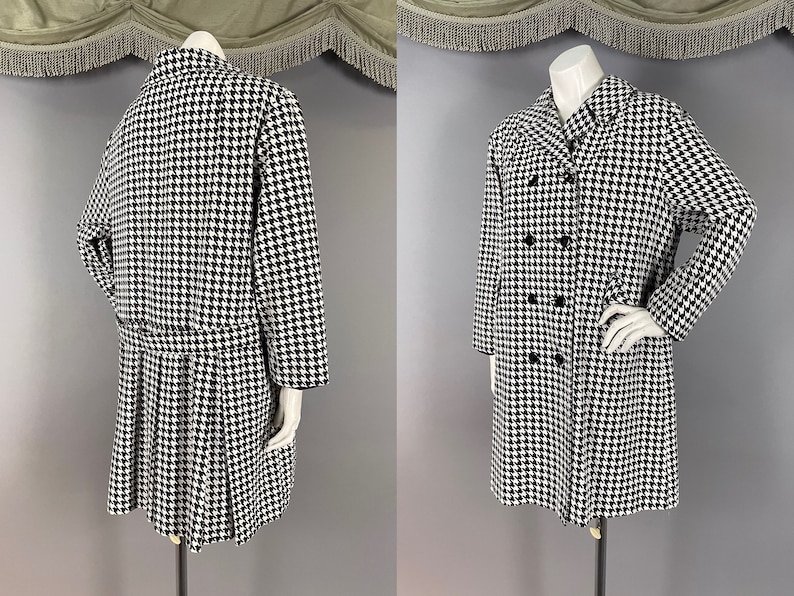 May include: A black and white houndstooth pattern coat with a double-breasted design. The coat features a pleated skirt and long sleeves. The coat is displayed on a mannequin.