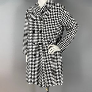 May include: A black and white houndstooth coat with a double-breasted design. The coat features a classic collar and long sleeves. The coat is displayed on a mannequin.
