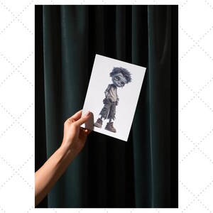 May include: A white card featuring a cartoon illustration of a zombie boy with gray skin, torn pants, and brown boots. The card is held against a dark green curtain background.