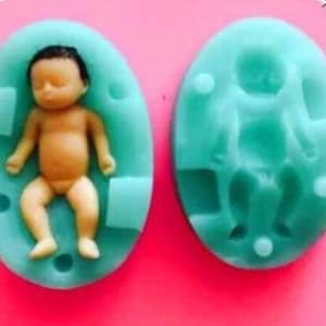 Może przedstawiać: Dwa silikonowe foremki do robienia ciast lub innych smakołyków w kształcie dziecka. Jedna foremka przedstawia dziecko leżące na plecach, druga przedstawia dziecko siedzące.