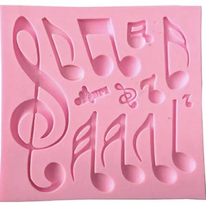 May include: Pink silicone mold with multiple musical note shapes, including a treble clef, a quarter note, and an eighth note.