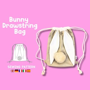 Op de afbeelding: Een beige trekkoordtas met witte konijnenoren en een pluche witte staart. De tas heeft een wit trekkoord en de tekst "Bunny Drawstring Bag" staat boven de tas. De tekst "Sewing Pattern" staat onder de tas. De afbeelding bevat ook vlaggen voor het Verenigd Koninkrijk, Duitsland, Frankrijk, Italië en Spanje.