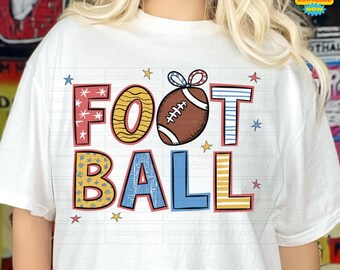 May include: A white t-shirt with a colorful graphic design that says "FOOTBALL" with a football in the middle. The letters are decorated with stars, stripes, and polka dots.