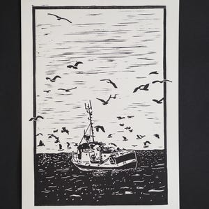 Könnte beinhalten: Schwarz-Weiß-Linolschnitt eines Fischerbootes auf See, umgeben von Möwen. Das Kunstwerk zeigt das Boot mit detaillierten Linien vor einem strukturierten Ozean und Himmel, wodurch eine dynamische Szene entsteht.