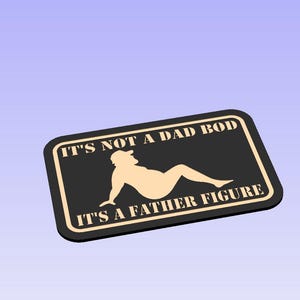 May include: Black rectangular sign with a gold border and text that reads "IT'S NOT A DAD BOD IT'S A FATHER FIGURE". The sign features a beige silhouette of a person reclining. The background is a light blue.