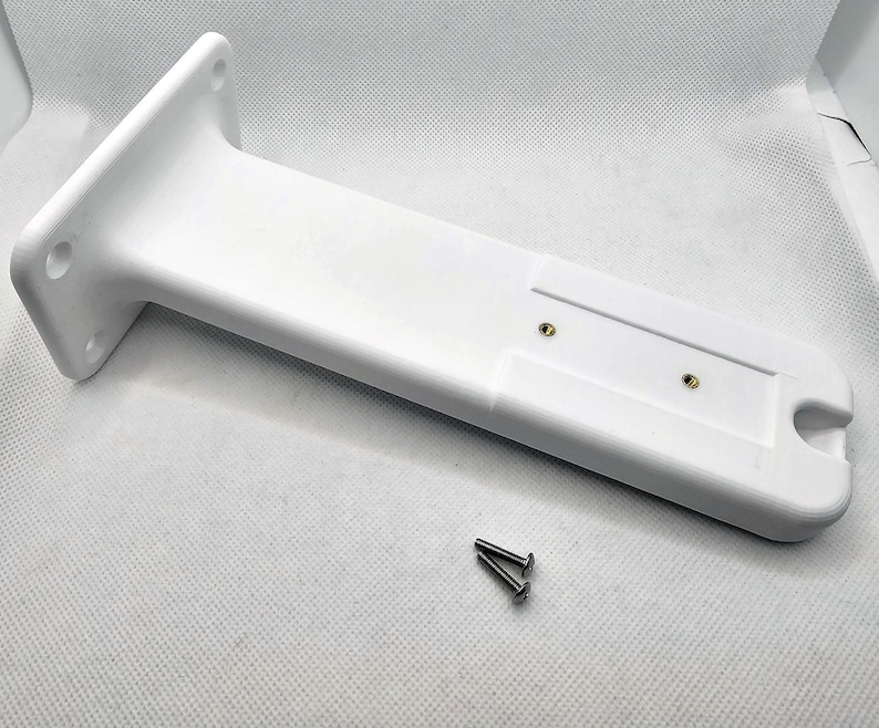 May include: White plastic mounting bracket with two screw holes and a slot for a cable. Two silver screws are included.