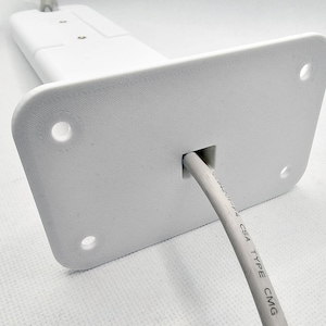 May include: White plastic wall mount with a hole for a cable. The cable is white and has the text "UL 1424 CSA TYPE CMG" printed on it.