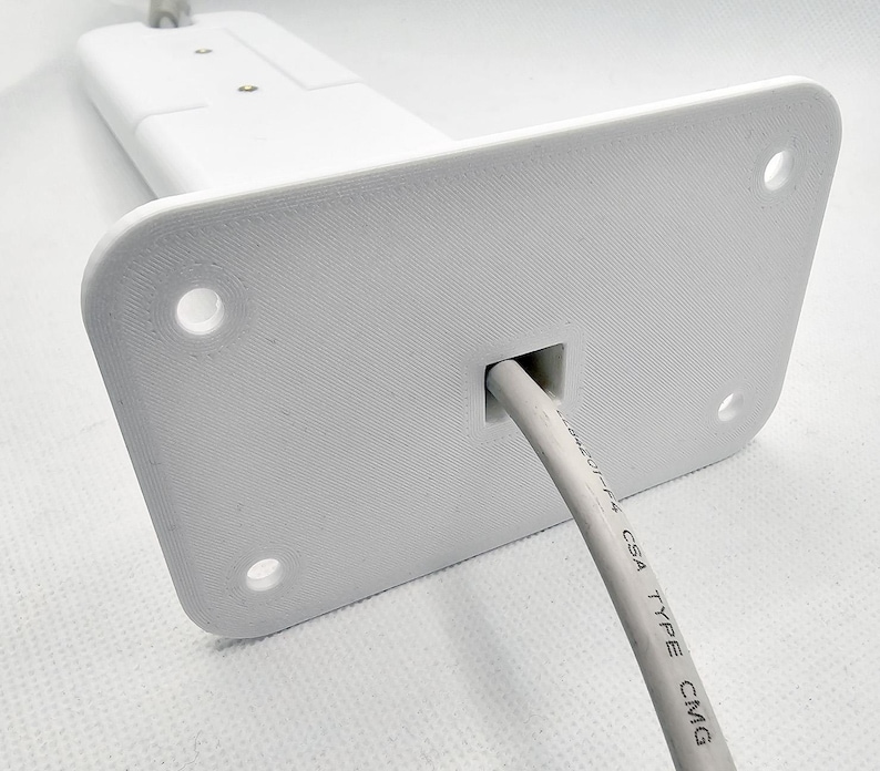 May include: White plastic wall mount with a hole for a cable. The cable is white and has the text "UL 1424 CSA TYPE CMG" printed on it.