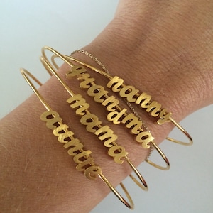 May include: Four gold bangle bracelets with the words "mommy", "grandma", "mama", and "auntie" engraved on them.