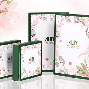 Peut inclure: Quatre bo&icirc;tes vertes avec des motifs floraux blancs et le texte "ALIN YERUSHALMI Jewelry Design".
