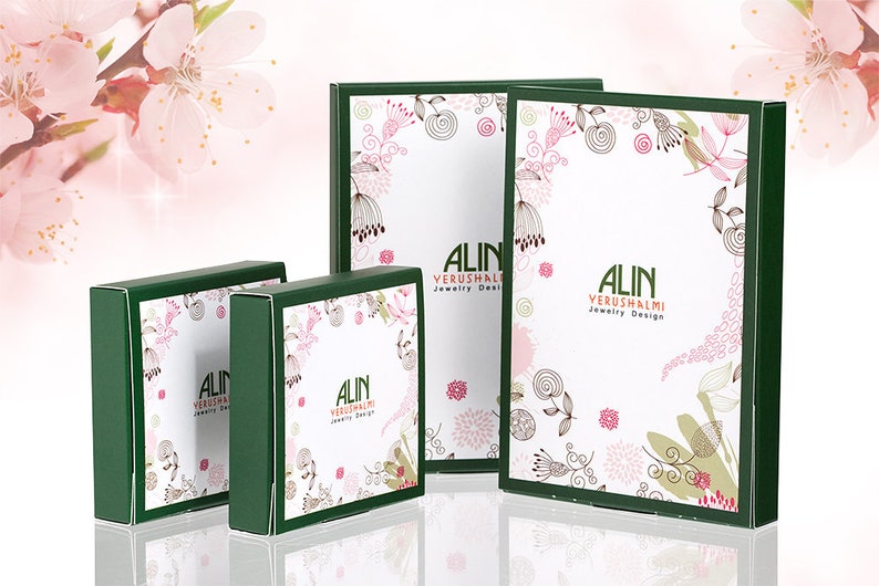 Peut inclure: Quatre bo&icirc;tes vertes avec des motifs floraux blancs et le texte "ALIN YERUSHALMI Jewelry Design".