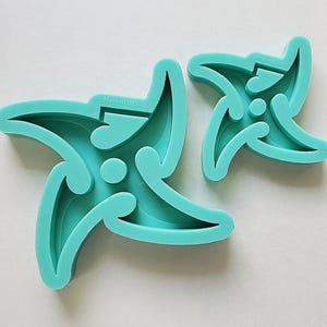 以下が含まれることがあります： 複雑なデザインが施された、5 本の尖った星の形をしたターコイズ色のシリコンモールドが 2 つ。モールドは、装飾的なレジン工芸品を作るのに最適です。