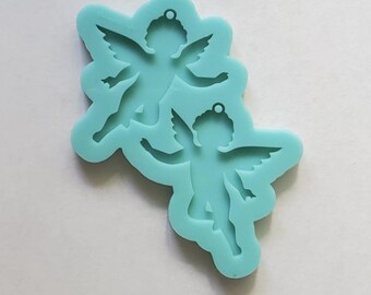 May include: A light blue silicone mold with two angel shapes. The mold is designed for making resin crafts.