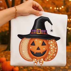 May include: A white Halloween tote bag featuring an orange pumpkin with a smiling jack-o'-lantern face. The pumpkin wears a black witch's hat with a purple and orange plaid band. A small spider hangs from the hat.