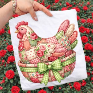 May include: White t-shirt featuring a patchwork hen design. The hen is in a basket with a green gingham bow. The hen's body is made of various floral and heart-patterned fabrics in pink, green, and red.