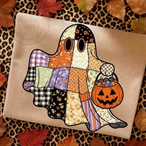 May include: A graphic illustration of a ghost made of various patchwork fabric patterns including floral, plaid, and polka dot prints in orange, black, purple, and cream. The ghost holds an orange jack-o'-lantern bucket filled with colorful candy.