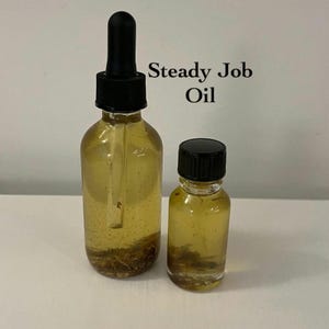 Könnte beinhalten: Zwei Glasflaschen mit Steady Job Oil. Die größere Flasche hat eine schwarze Pipette, und die kleinere Flasche hat einen schwarzen Deckel. Beide Flaschen enthalten eine gelbe Flüssigkeit mit Sediment am Boden. Der Text "Steady Job Oil" ist auf dem Bild aufgedruckt.