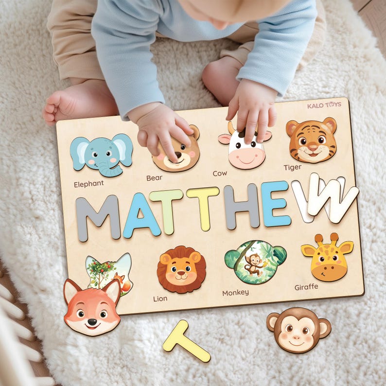 May include: Wooden puzzle with the name "MATTHEW" and animal-shaped pieces. The puzzle includes an elephant, bear, cow, tiger, fox, lion, monkey, and giraffe. The puzzle is made by KALO TOYS.