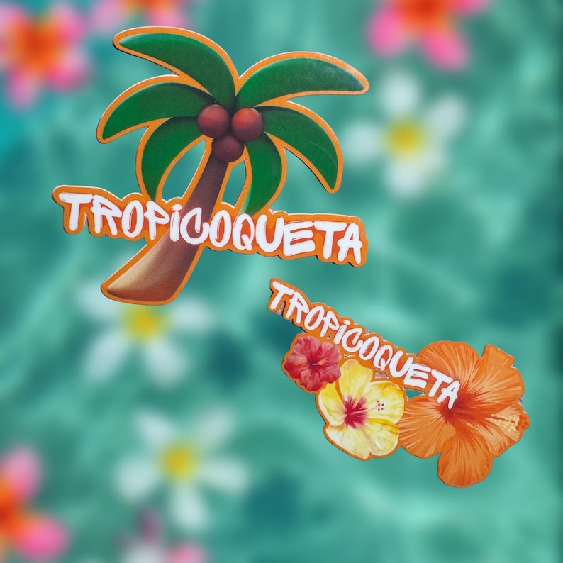Op de afbeelding: Twee tropische stickers met de tekst "TROPICOQUETA". E&eacute;n sticker toont een palmboom met groene bladeren, een bruine stam en rode kokosnoten. De andere heeft drie bloemen in rood, geel en oranje.