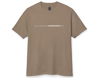 May include: A tan-colored t-shirt with the text "IN ALL YOUR WAYS ACKNOWLEDGE HIM." printed in white. The shirt has short sleeves and a crew neck. The fabric appears to be a soft, comfortable material.