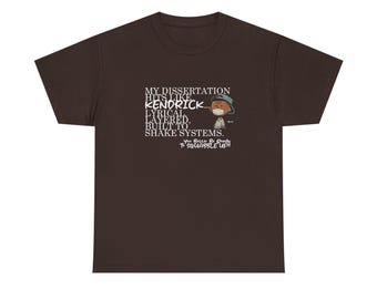 May include: A brown t-shirt with a white graphic of a cartoon character wearing a mask and the text "My dissertation hits like Kendrick, lyrical layered, built to shake systems. You better be ready to squabble up."