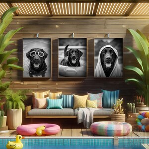 Può includere: Tre ritratti di cani in bianco e nero incorniciati sono appesi sopra un divano esterno in legno con cuscini colorati. Una piscina con giocattoli gonfiabili e piante in vaso completano la scena. I ritratti mostrano un Labrador Retriever nero.